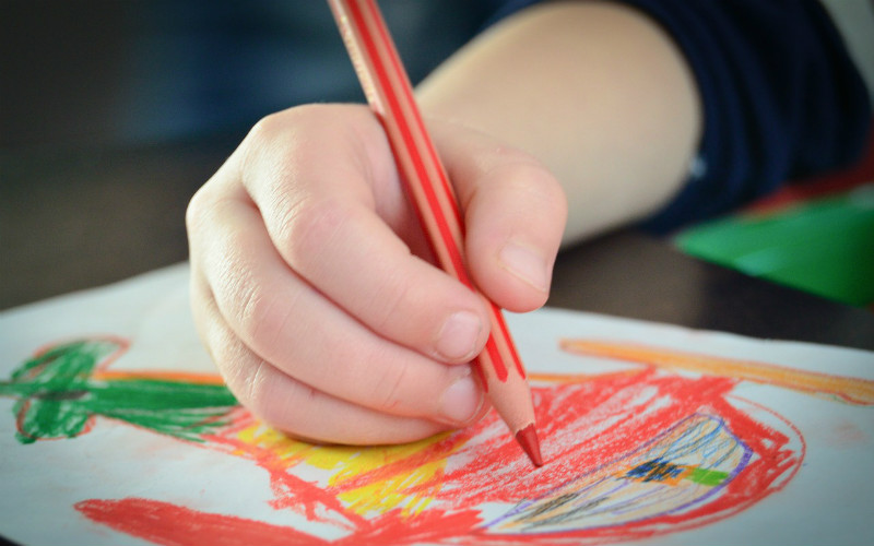child drawing with pencils