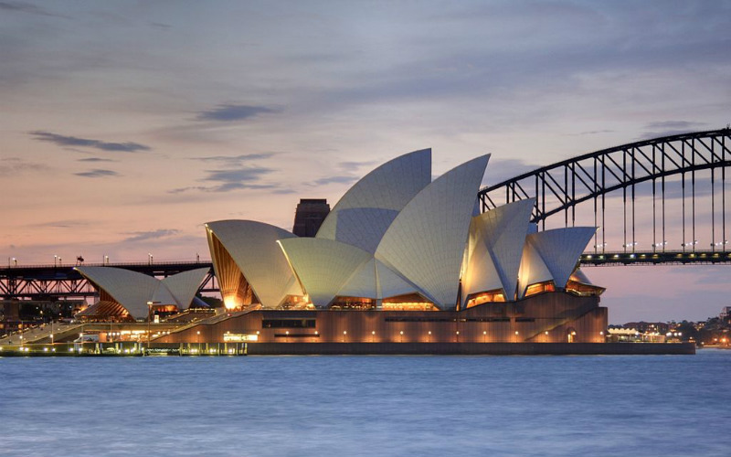 The Sydney Opera House at twilight, with the Sydney Harbour Bridge in the background