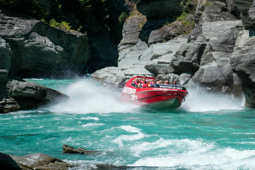 Jet boat in choppy blue rivers across Queenstown